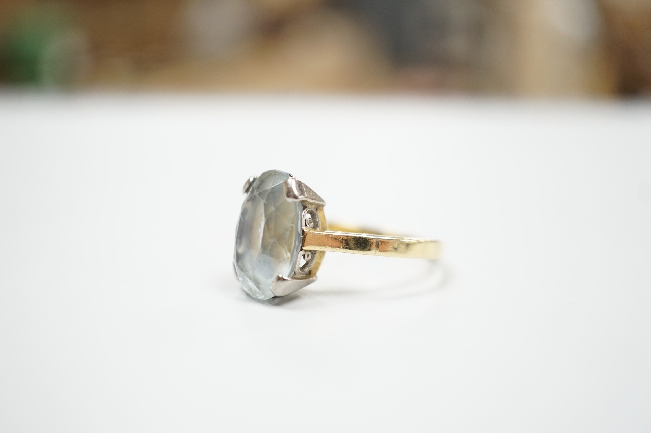 An 18ct and oval cut aquamarine set ring, (shank cut), size P, gross weight 5.3 grams.